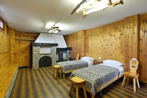 2 camas en una habitación con chimenea en La Grolla Apartments, en Manerba del Garda