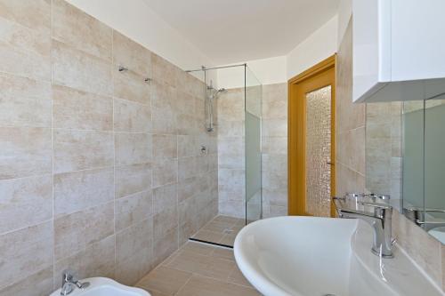 ein Badezimmer mit einem Waschbecken und einer Badewanne in der Unterkunft La Grolla Apartments in Manerba del Garda
