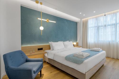 1 dormitorio con 1 cama y 1 silla azul en Acropolis Magenta Luxury Suites en Atenas