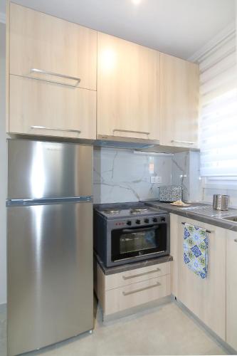 a kitchen with a stainless steel refrigerator and cabinets at Sandra's luxury stay in Akti Salonikiou