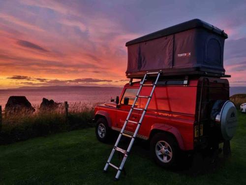 a red jeep with a ladder on top of it at Bonniebreaks in Avoch