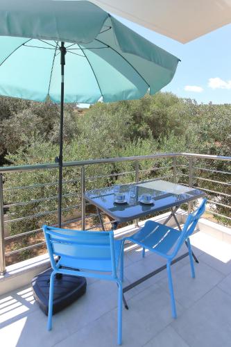 a table and two chairs and an umbrella on a balcony at Sandra's luxury stay in Akti Salonikiou