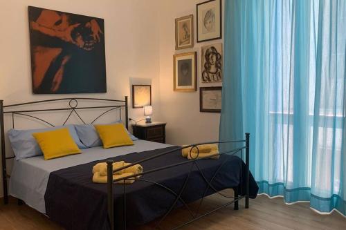 a bedroom with a large bed with blue curtains at Casa Franca a Marzamemi in Marzamemi