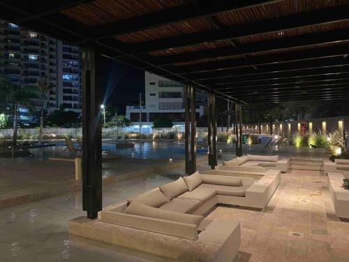 a row of white couches under a pavilion at night at Reserva del Mar - Apto con vista al mar in Santa Marta