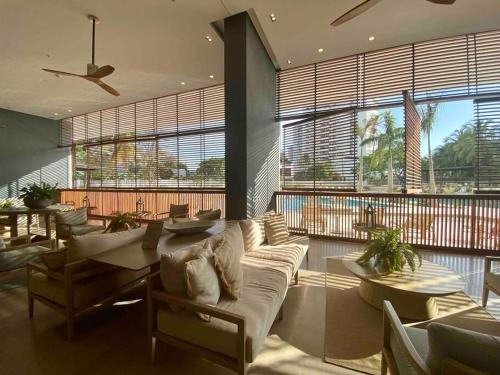 a living room with a couch and tables and windows at Reserva del Mar - Apto con vista al mar in Santa Marta