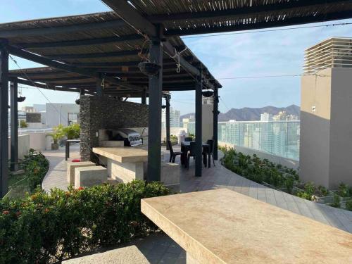 a patio with benches and tables on a roof at Reserva del Mar - Apto con vista al mar in Santa Marta