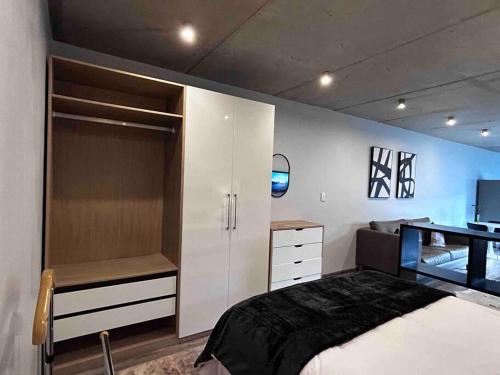 a bedroom with a bed and a desk in it at Waterkloof Nature Reserve Studio Apartment in Pretoria