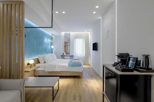 Habitación de hotel con cama y sala de estar. en Acropolis Magenta Luxury Suites en Atenas