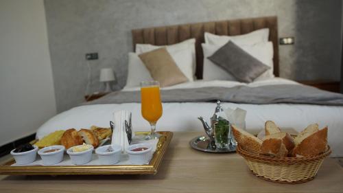 una bandeja de comida en una mesa junto a la cama en Hotel Riad Taounate en Taounate