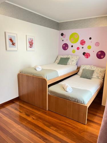 two twin beds in a room with wooden floors at Agradable casa con jacuzzi climatizado exterior en pleno Urdaibai in Busturia