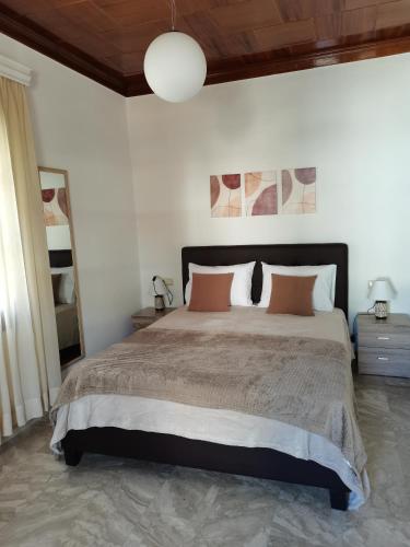 1 dormitorio con 1 cama grande con almohadas de color naranja en Summer Life, en Panayia