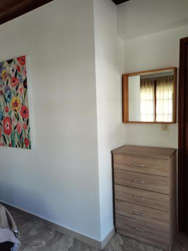a bedroom with a dresser and a mirror on a wall at Summer Life in Panayia