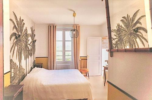 - une chambre avec un lit blanc et des palmiers dans l'établissement le Saint-Etienne, à Aubazines