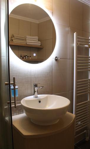Un baño con un lavabo blanco y un espejo. en Myrina View 2, en Mirina