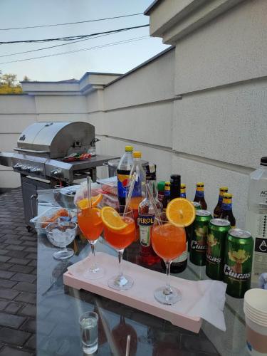 a table with glasses of orange juice and bottles of soda at Regal Guest House in Sighetu Marmaţiei