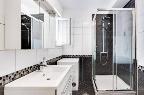 een witte badkamer met een wastafel en een douche bij NEW apartmant for 5 in Solin