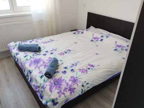 Una cama con colcha floral. en Bucium Apartament en Iaşi