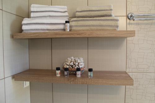 un estante de baño con toallas y flores. en Myrina View 2 en Mirina