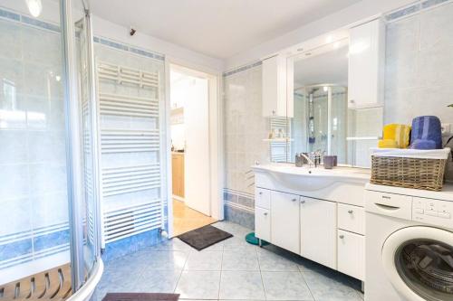 y baño con lavabo y lavadora. en Family Home Stay Ma-Rich with Free Parking en Liubliana