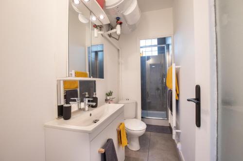biała łazienka z toaletą i umywalką w obiekcie *Le Cosy* 3 chambres hypercentre - Parking - Wifi w Awinionie