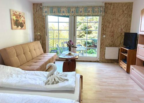 ein Wohnzimmer mit einem Bett, einem Sofa und einem TV in der Unterkunft Homestay Sweet Island in Gager