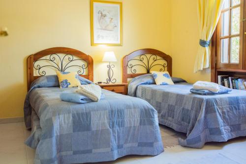 a bedroom with two beds with blue and white sheets at Villa Isa sea views in Playa Blanca