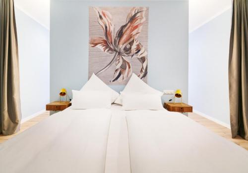 a white bed with white pillows in a bedroom at Design Studio I Stadtzentrum I Küche I Netflix in Bingen am Rhein