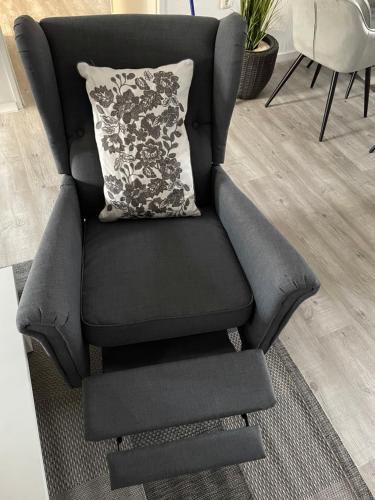 a black chair with a pillow in a living room at Haus Mariechen in Hooksiel