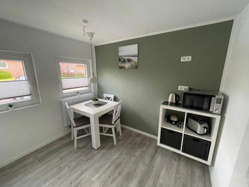 a small room with a table and a microwave at Haus Mariechen in Hooksiel