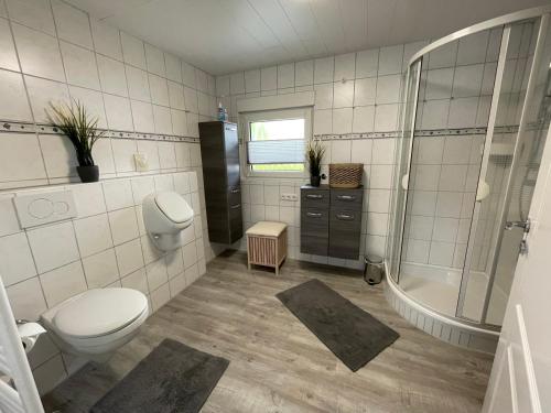 a bathroom with a toilet and a shower and a sink at Haus Mariechen in Hooksiel