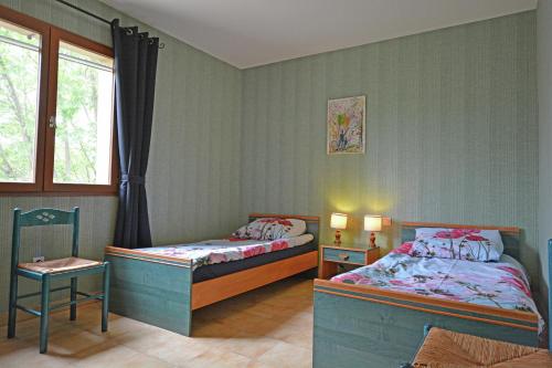 une chambre avec deux lits et une fenêtre dans l'établissement Villa Vignes, à Saint-Césaire-de-Gauzignan