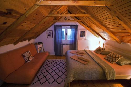 a bedroom with a bed and a couch in a attic at Planinska kuća Agroturizam Kućica Mostar in Mostar