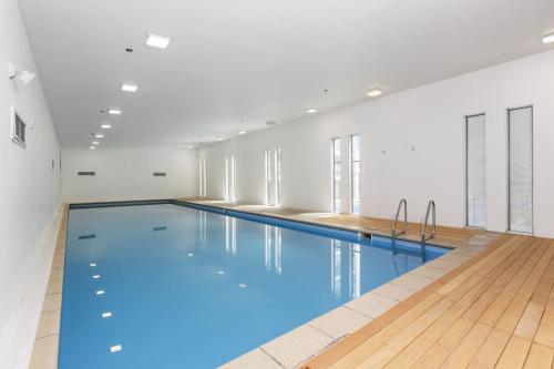 a large swimming pool with blue water in a building at The Landings Parnell in Auckland