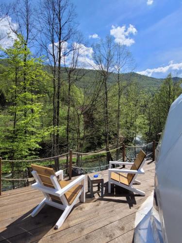 a deck with two chairs and a table with a view at Nomad Glamping in Šipovo
