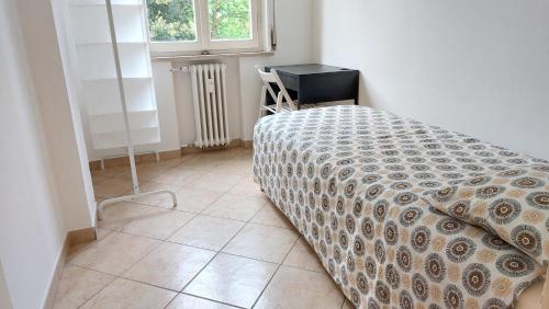 1 dormitorio con cama con edredón y ventana en XXV Aprile, en Ferrara