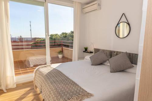a bedroom with a bed and a large window at Apartamento Sereno 1 - Piscina, Garaje, Terraza y Playa in Los Caños de Meca