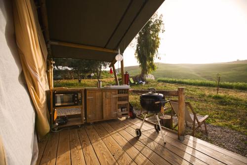 une tente avec un grill sur une terrasse en bois dans l'établissement Tienda de Safari Almagro, à Montecorto