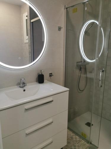 a bathroom with a sink and a shower with a mirror at Apartamento Canyelles playa in Roses
