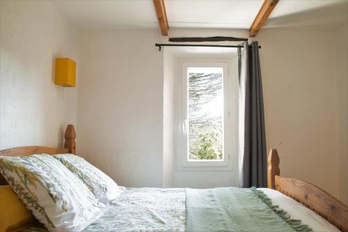 1 dormitorio con cama y ventana en La Pigoussette en Valensole