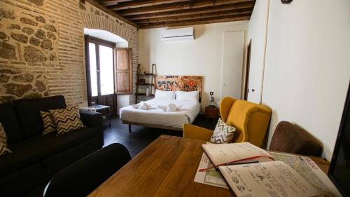 een woonkamer met een bed en een tafel en stoelen bij Tiempo de Toledo in Toledo