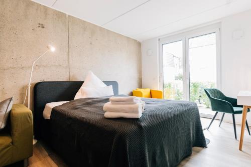 a bedroom with a bed with towels on a table at City-Living Appartement in Bielefeld