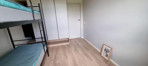 a small room with two bunk beds and a hallway at 62m2 Apartament PREMIUM Łąki i Pola, ELEKTRYCZNE ROLETY, KLIMATYZACJA, GARAŻ, ŁADOWARKA AUT ELEKTRYCZNYCH in Suwałki