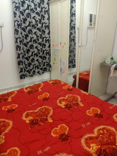 Un dormitorio con una cama roja con flores. en Private room for upto 4 peope, en Sharjah