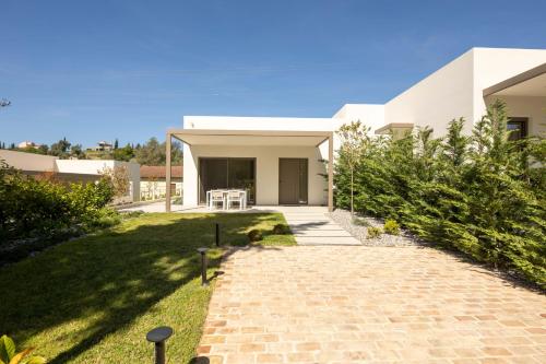 a house with a brick walkway in front of a yard at Stablo Residence in Kanálion