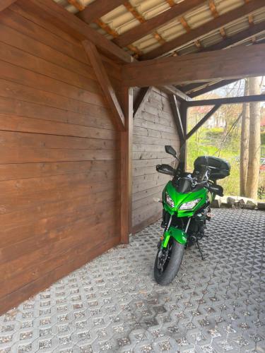 Przy Stoku i Potoku في فيسلا: دراجة نارية خضراء متوقفة في مرآب