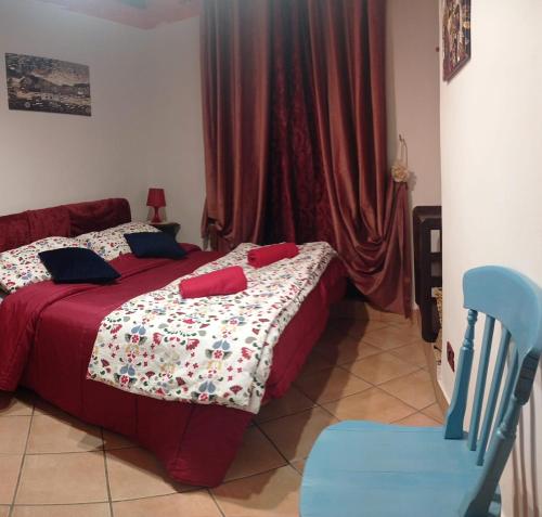 a bedroom with a bed and a blue chair at Casa Appartamento per Vacanze - CASA CAMPANFIORE - Al Centro Storico di ZAGAROLO - PER 4 OSPITI in Zagarolo
