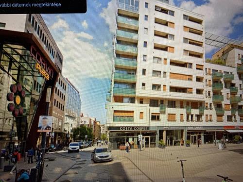 Blick auf eine Stadtstraße mit einem hohen Gebäude in der Unterkunft Corvin Fontana Apartment in Budapest