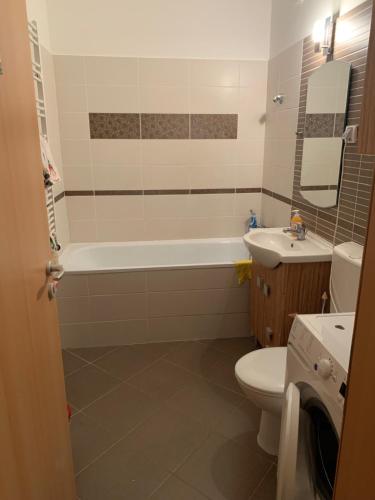 ein Badezimmer mit einer Badewanne, einem WC und einem Waschbecken in der Unterkunft Corvin Fontana Apartment in Budapest