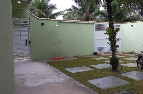 una casa con un garaje con una palmera al lado en pousada Cantinho da mata en Paraty