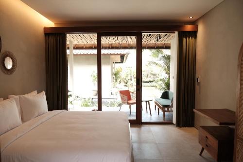a bedroom with a bed and a patio with a table at Cloudspace Ubud in Ubud
